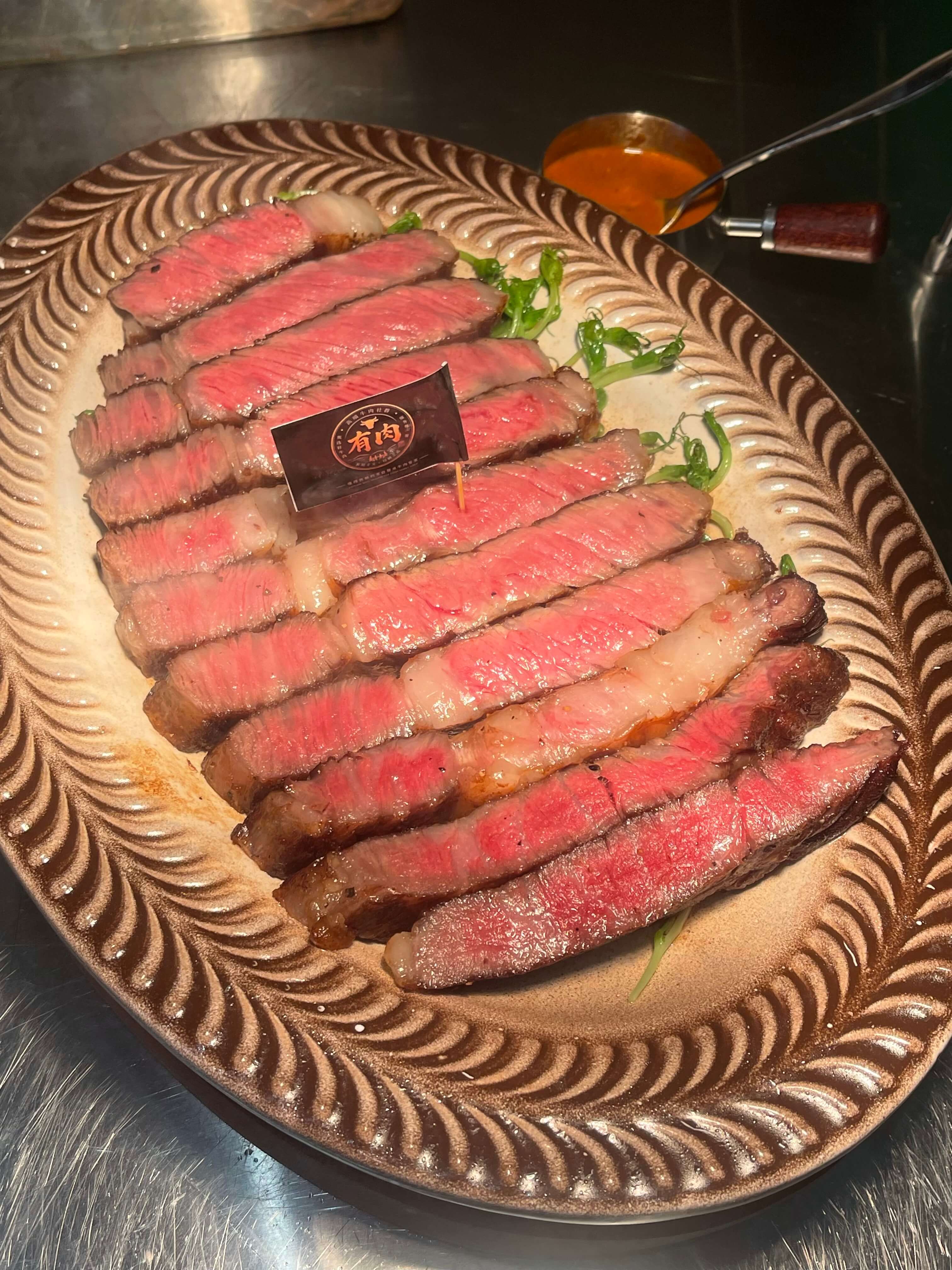 有肉实拍:牛排切片与品牌桌牌